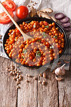 Indian cuisine: Chana masala with ingredients close-up. vertical