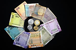 Indian currencies. 50, 100, 200, 500 rupee notes and coins. Indian currency isolated on black background.