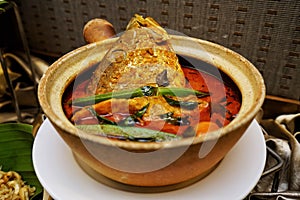 Indian Curry Fish Head with Tomato, Ladies Fingers and Curry Leaves in a Claypot