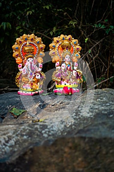 Indian deities Lord Ganesha and Goddess Lakshmi sculptures placed on stone top