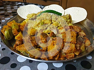 Indian delicacy with pumpkin and potato curry, green chilly, khichdi and rice crispy