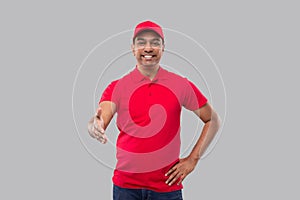 Indian Delivery Man offering hand to shake. Greeting and welcoming gesture. Delivery advertisement concept. Delivery man Hand