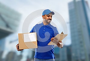 Indian delivery man with parcel box and clipboard