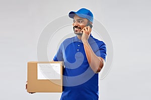 Indian delivery man with smartphone and parcel box