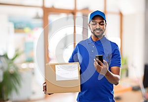 Indian delivery man with smartphone and parcel box