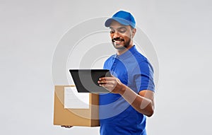 Indian delivery man with tablet pc and parcel box