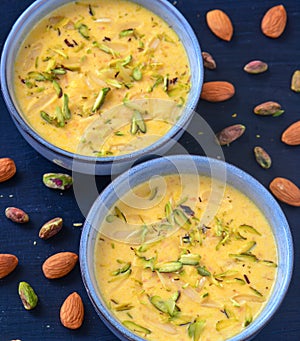 Indian dessert- kesar pista basundi with nuts in background photo