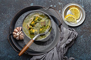 Indian dish Palak Paneer in bowl on rustic stone table