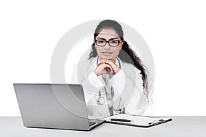 Indian doctor with laptop and clipboard