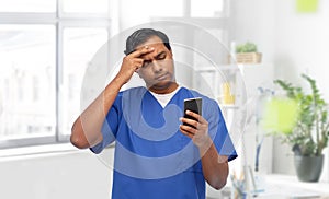 indian doctor or male nurse using smartphone