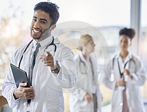 Indian doctor, portrait and healthcare worker pointing at you for we are hiring. Medical staff, hospital employee and