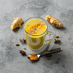 Indian drink turmeric golden milk in glass. Golden latte on light background ingredients for cooking