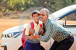 Indian family driving boys to school In front of house gates