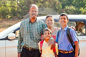 Indian family driving boys to school In front of house gates