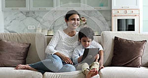 Indian family mom and boy use interactive app on pad