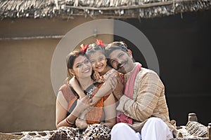 Indian family sitting on traditional bed in village