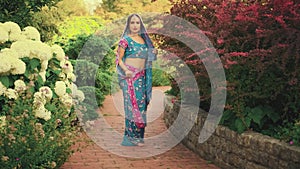 Indian fantasy woman posing in blooming spring nature park. Oriental girl