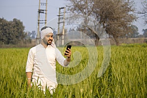 Indian farmer clicking photo of his healthy wheat crop