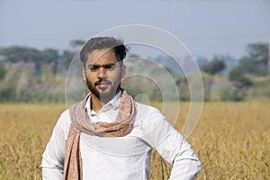 Indian farmer with paddy field in back