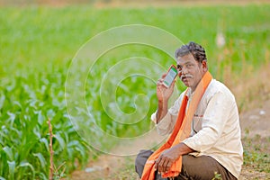Indian farmer using mobile phone at corn field