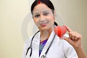 Indian female doctor holding a beautiful red heart shape