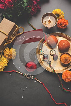 Indian festival Raksha Bandhan with rakhi bracelets, presents, rice and kumkum and sweets in plate