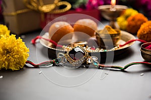 Indian festival Raksha Bandhan with rakhi bracelets, presents, rice and kumkum and sweets in plate