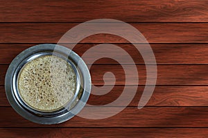 Indian filter coffee cup on wooden table background. Top view with copy space