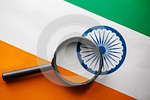 The Indian flag is visible through a magnifying glass. Spies and Observations for India India. Monitoring the state of India