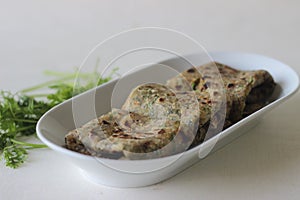 Indian flat bread made of whole wheat flour with grounded flax seed and fresh coriander leaves. Locally known as coriander paratha