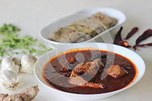 Indian flat bread made of whole wheat flour with grounded flax seed and fresh coriander leaves served with red gravy fish curry