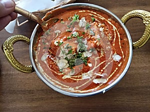 Indian food including curries, spice sauce and naan bread.