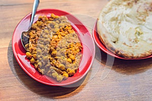 Indian Food or Indian curry in a copper brass serving bowl with nan bread or roti