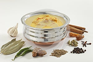 Indian Food- Kadhi with gatte in stainless steel pot with spices. photo