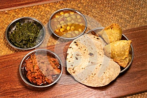 Indian food with spice curry and naan bread and samosa on wooden table in restaurant