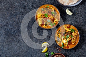 INDIAN FOOD. Traditional KERALA FISH CURRY with naan bread, gray plate, black background photo