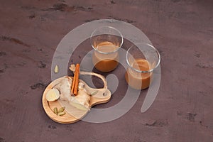 Indian ginger tea with milk and spices on brown background.  Popular hot drink in India and Nepal