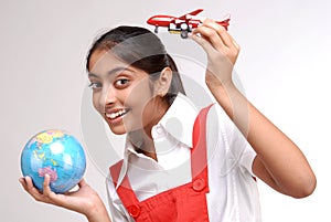 Indian girl holding globe and a toy aircraft