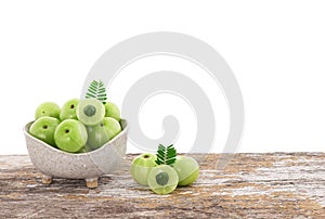 Indian Gooseberry or phyllanthus emblica fruits in bowl on the wooden table with clipping path