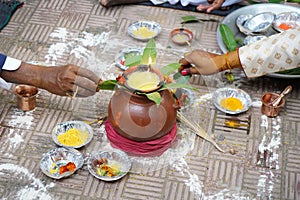 Indian groom and father holding leaves in pooja during marriage.