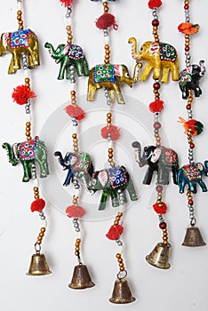 Handmade wind chimes with bells and small decorated toy elephant
