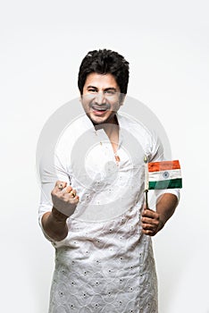 Indian handsome boy or man in white ethnic wear holding indian national flag and showing patriotism, standing isolated over white