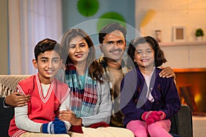 Indian happy family portraitshot in winter wear - concept of family bonding, holiday gathering and leisure lifestyles