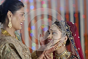 Indian Hindu Bride getting ready with help of moth