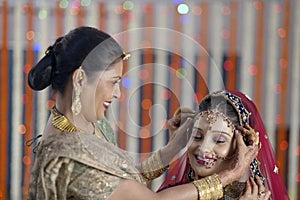 Indian Hindu Bride getting ready with help of moth