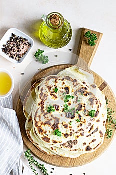 Indian homemade traditional flatbread with fresh parsley and olive oil. Chapati, roti or naan Indian crispy flatbread. Top view