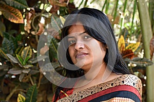 The Indian housewife in the casual clothing on a forest background