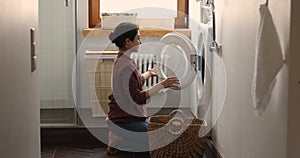 Indian housewife doing housework, washing bath towels in laundry room