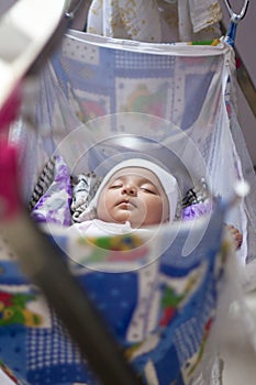 Indian Infant baby sleeping in blue swing