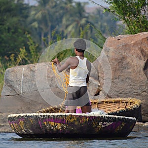 Kid fishing from his shell on the river